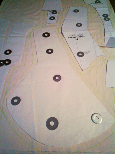 the pieces for a jacket laid on unbleached cotton fabric: it's not the most efficient layout, and a lot of the seam allowances are irregular because there wasn't enough space between the corners of the pieces.