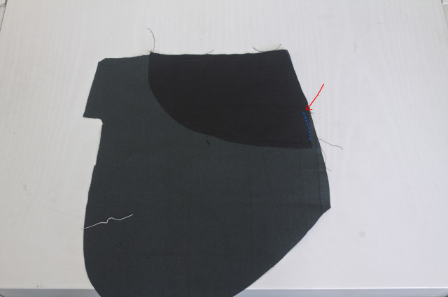 the pocket piece of a pair of jeans, with the fashion fabric fashion sewn and basted on top: about 4 cm of basting seam on the side are missing, but the facing is still stable enough for further sewing.