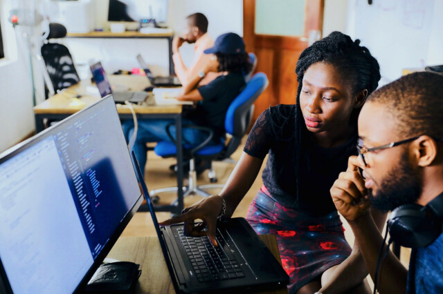 two people in front of desktop