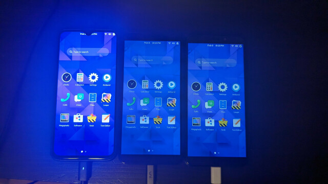 Three phones running the GNOME Shell mobile environment. They all have the same wallpaper and the same apps, and they are all showing the home screen.