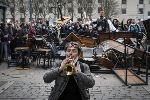 Un uomo suona la tromba davanti a una barricata durante-una manifestazione a Lione in #Francia il 7 marzo 2023 foto di Laurent Cipriani