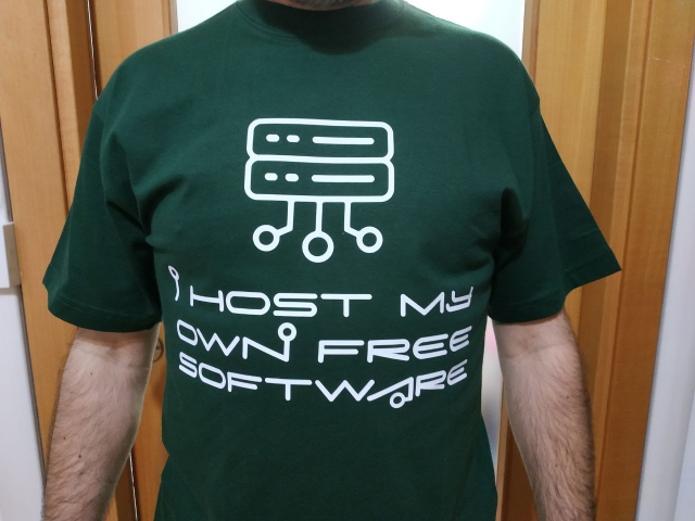 Foto di un losco individuo che indossa una maglietta verde con scritto in bianco "i host my own free software"