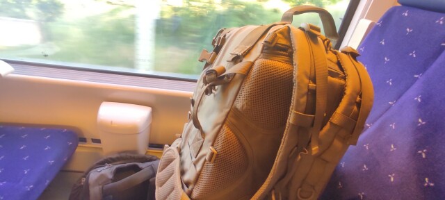 Luggage on train seat while the landscape goes by the windows 