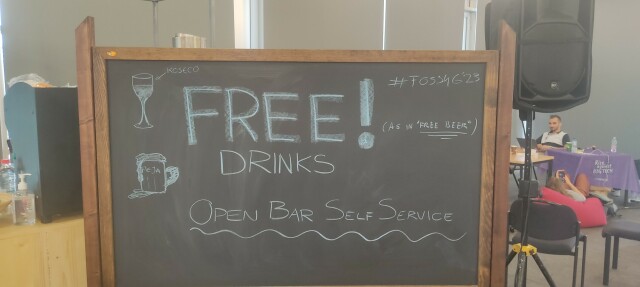 Sign saying "Free drinks (as in free beers)"