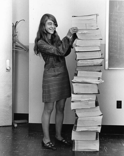 Margaret Hamilton next to her printed out software that’s taller than she is.