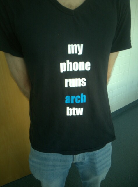 A tshirt which reads "my phone runs arch btw"