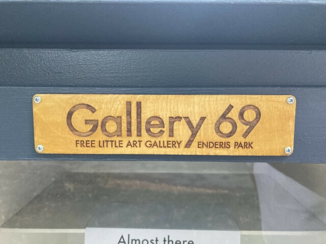 A laser etched sign that says "Gallery 69 - Free Little Art Gallery - Enderis Park"