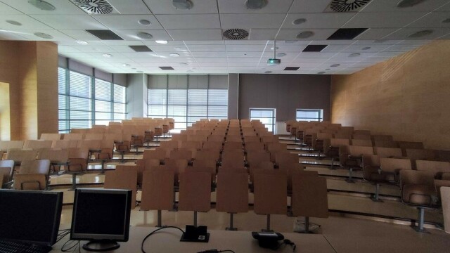 A photo of a large room with 120 seats and a projector.