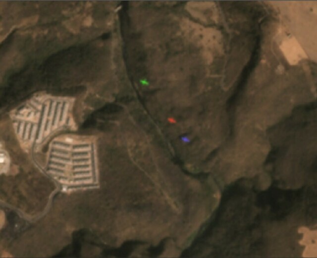 satellite imagery showing 3 different ghosts, red, green and blue, generated by a plane flying over a creek at the same moment the satellite acquired the image. The plane speed makes its image appear in 3 different locations, corresponding to each detector in the satellite sensor.