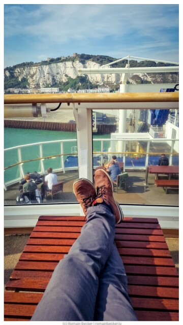 Stretched legs in front of cliffs of Dover, overseen by Dover castle. The scene is on board of a ferry outbound to Calais.