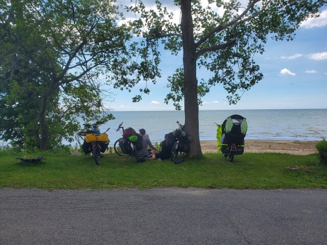 Four bikes and some picnicners next to the shore of Lake Erie