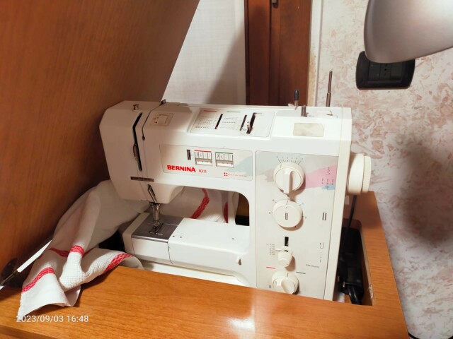 Foto di una macchina per cucire Bernina modello 1011, con il suo relativo mobiletto.