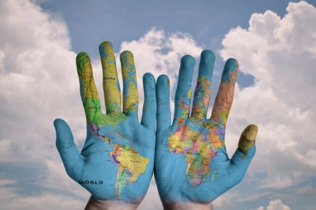 Shows a map of the world painted on two hands