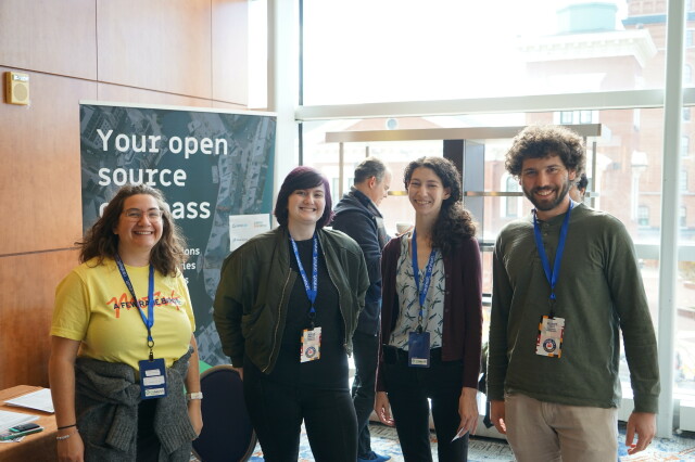 OSGeo Booth with hapless bystanders for photo 