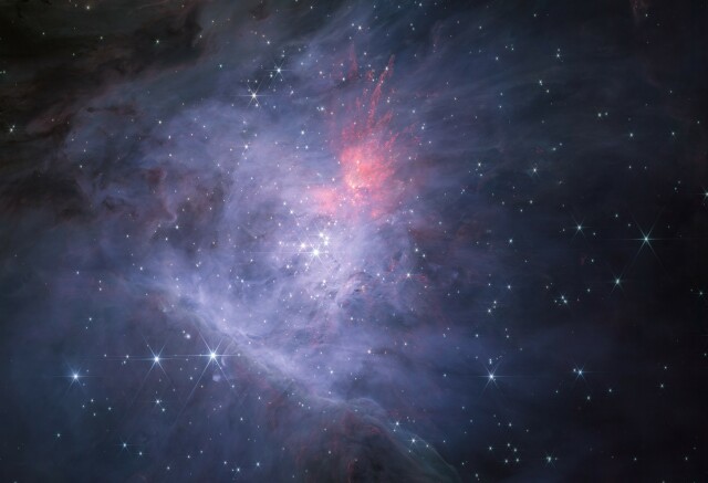 A wide-field image of the inner Orion Nebula & Trapezium Cluster as seen at shorter near-infrared wavelengths (1-2.1 microns) by JWST. The image is predominantly blue due to ionised hydrogen, but there are regions of brown due to dust absorption and bright red due to emission from shocked & fluorescent molecular hydrogen. There are thousands of stars, brown dwarfs, & planetary-mass objects strewn across the region, centred on the Trapezium OB stars.