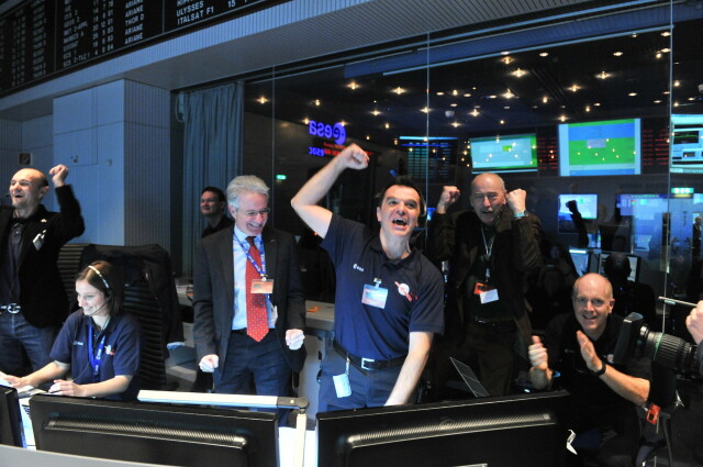 A photo taken by Jürgen Mai in the Main Control Room at the European Space Operations Centre in Darmstadt, Germany, on 20 January 2014, at the moment that the Rosetta spacecraft communicated with Earth after its 2.5 year hibernation. In the foreground from left: Emily Baldwin, Paolo Ferri, Andrea Accomazzo, Manfred Warhaut, & Mark McCaughrean. 