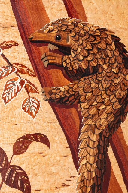 Close-up photo of the cabinet door, showing the marquetry pangolin. The image is made using hundreds of pieces of veneer in different colors.