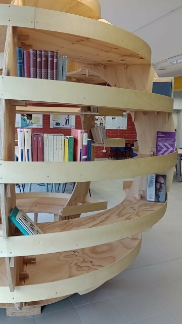 Una struttura in legno di forma sferica riutilizzata come scaffale circolare per il booksharing