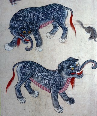 This is a drawing of a Bulgasari.

We see two identical creatures here. They have a navy blue body with small dots on them, probably emulating elephant or rhino skin. Their feet end in paws, like those of a tiger. Their tails are fringed with red hair and their torsos are rippled in pink, like armor.

Their heads are large with tufts of fur in blue and red around the cheeks, chin, and ears. Their mouths bear large scary teeth like that of a big cat and their noses are elephant trunks.
Their eyes are yellow, like a rhino's.

Their demeanor overall is menacing.