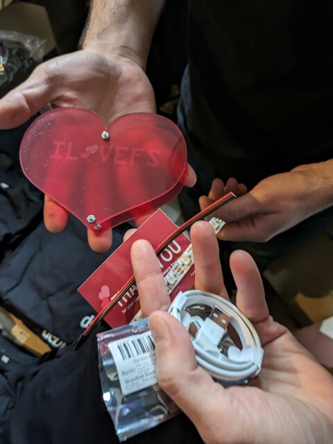 A plexiglass red heart with some tools to make it glow