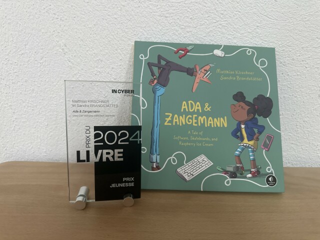 Image showing the French edition of the book 'Ada & Zangemann' standing close to the trophy