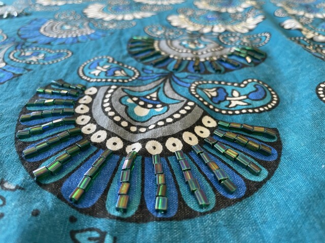 Same kaftan showing closeup of a blue bread fan. 