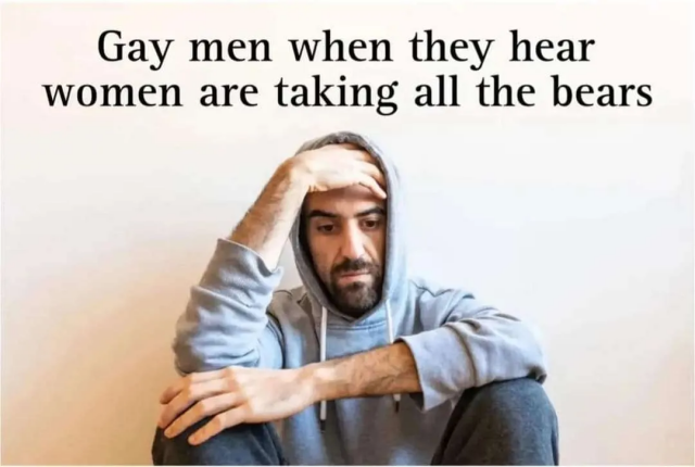 Photo of a man in hoody sitting on the floor looking kinda down, holding the head with one hand, the other resting on the knees, looking to the floor. Caption: "Gay men when they hear women are taking all the bears."