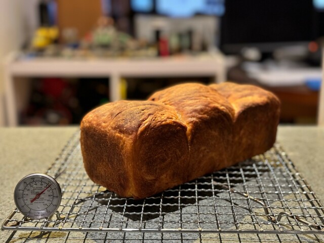 A three domed loaf on a cooling rack. 