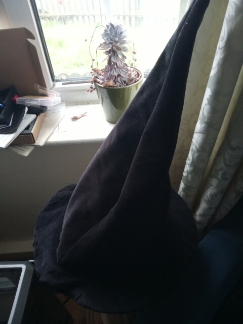 The witches hat black side out infront of a window 