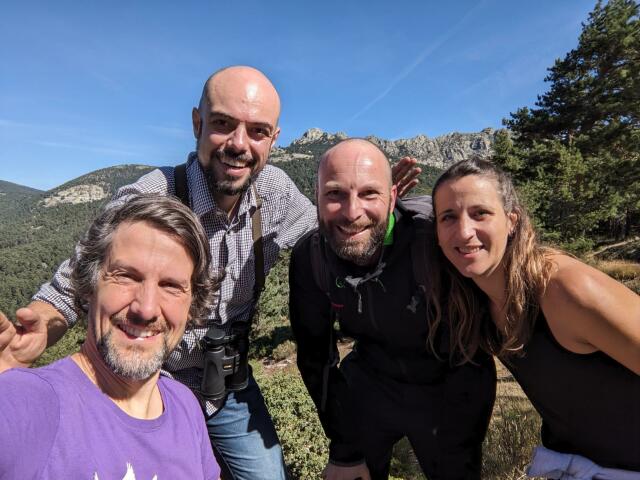 four people in good mood in front of mountain landscape.