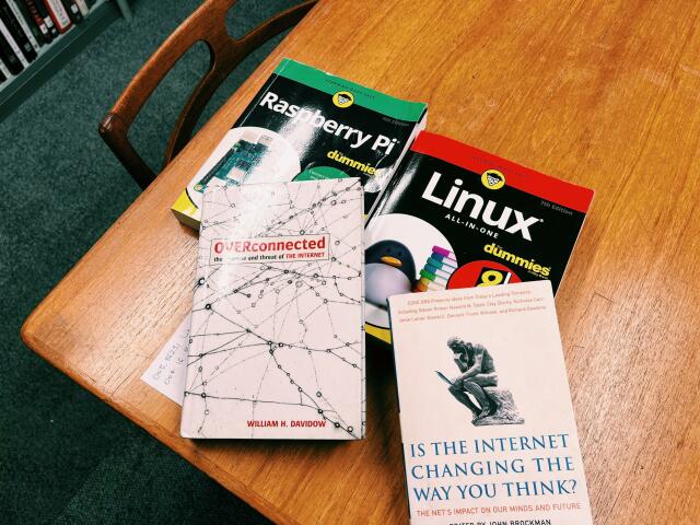 A photo showing a table at the library with books on it (which I am borrowing): Raspberry Pi for dummies, Linux all-in-one for dummies, OVERconnected and Is The Internet Changing The Way You Think? 